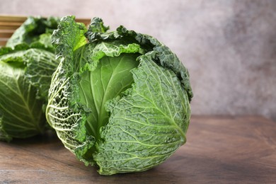 Photo of Fresh Savoy cabbages on wooden table, closeup