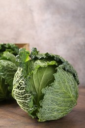 Photo of Fresh Savoy cabbages on wooden table, closeup