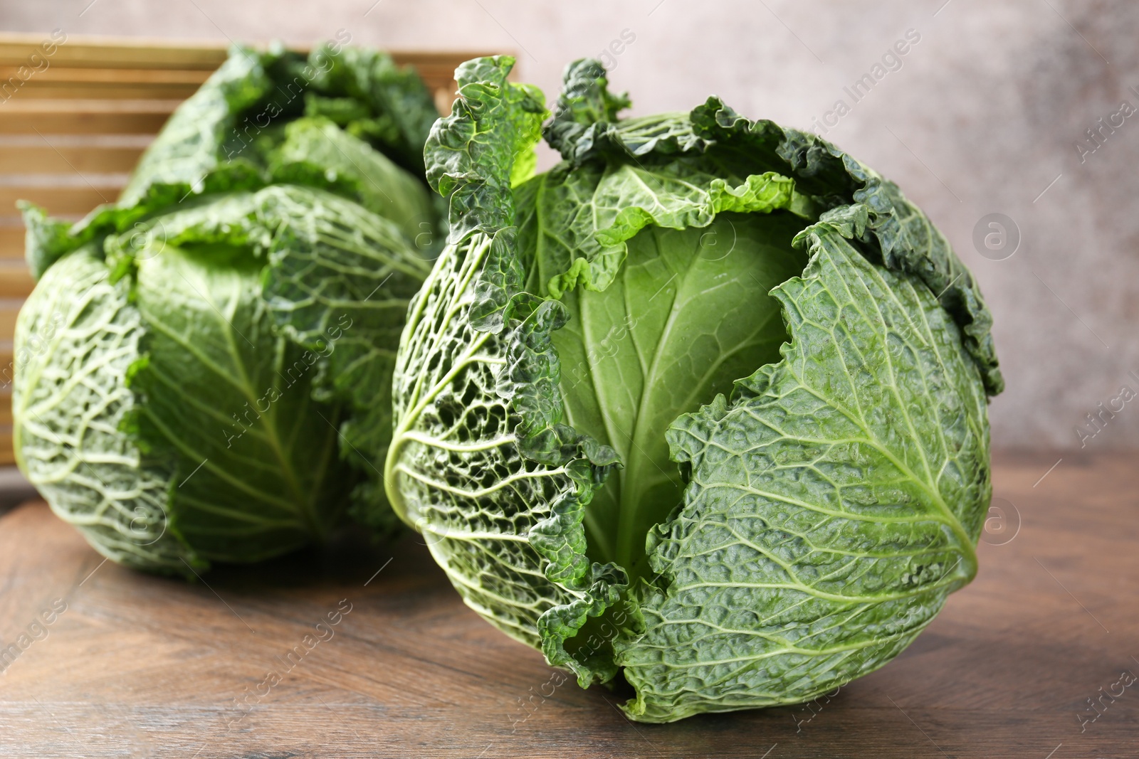 Photo of Fresh Savoy cabbages on wooden table, closeup
