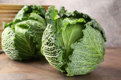 Photo of Fresh Savoy cabbages on wooden table, closeup
