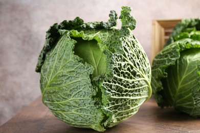 Photo of Fresh Savoy cabbages on wooden table, closeup