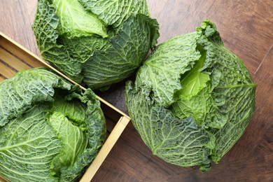 Photo of Fresh Savoy cabbages on wooden table, flat lay