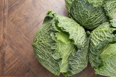 Photo of Fresh Savoy cabbages on wooden table, flat lay