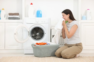 Photo of Woman with laundry near washing machine indoors