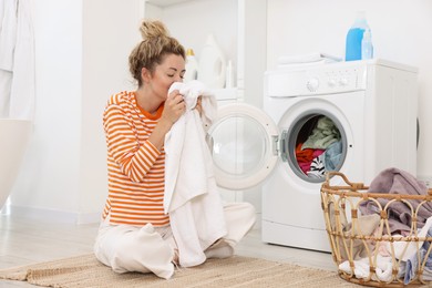 Photo of Woman with laundry near washing machine indoors