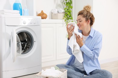 Photo of Woman with laundry near washing machine indoors