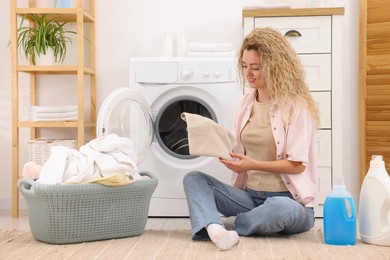 Photo of Woman with laundry near washing machine indoors