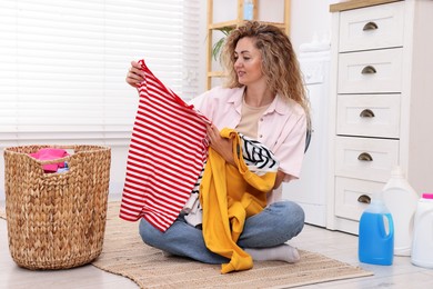 Photo of Woman with laundry on floor at home