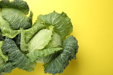 Photo of Fresh Savoy cabbages on yellow background, flat lay. Space for text