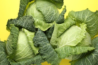 Photo of Fresh Savoy cabbages on yellow background, flat lay