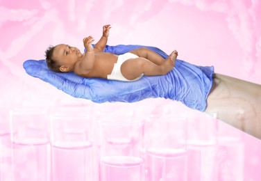 Image of In vitro fertilization (IVF). Cute little baby in doctor's hand against pink background with test tubes and DNA