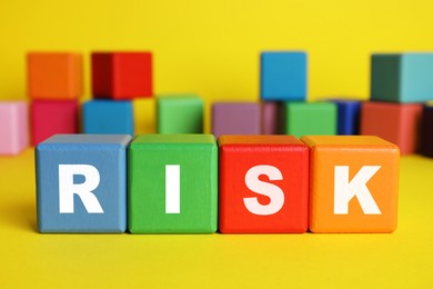 Image of Word Risk of wooden cubes with letters on yellow table