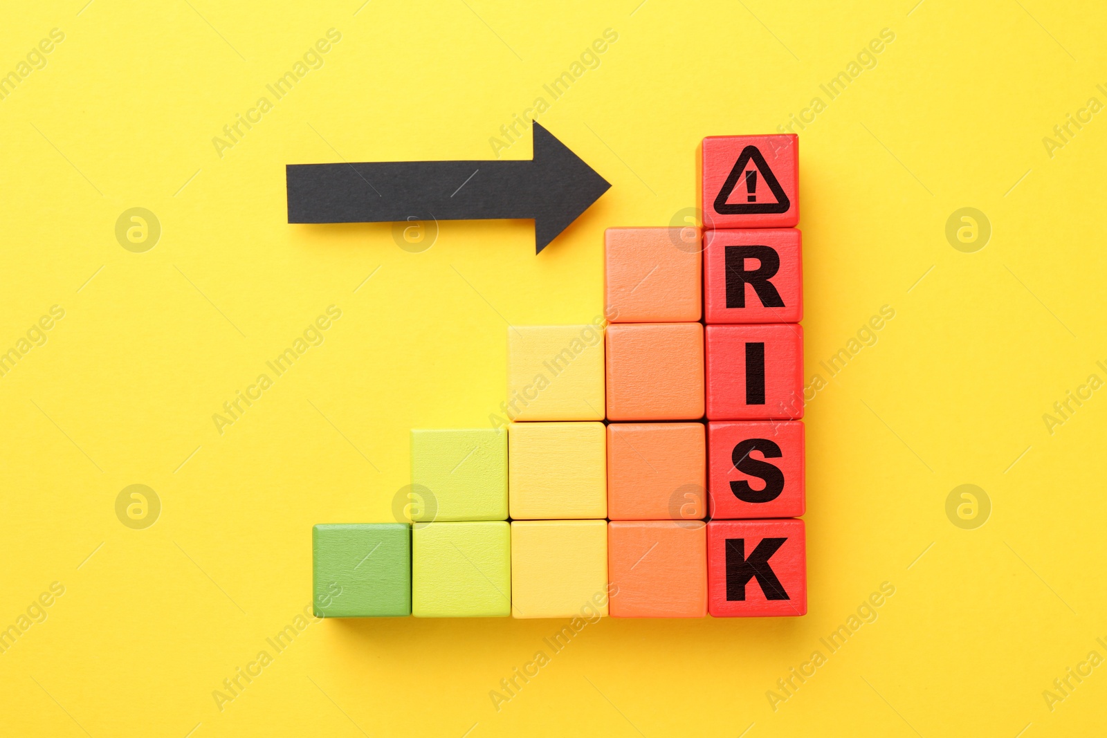 Image of Word Risk of wooden cubes with letters on orange background, top view. Arrow pointing at warning sign
