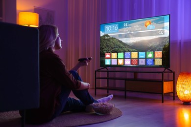 Image of Woman watching TV at home in evening. Menu with icons and information on display