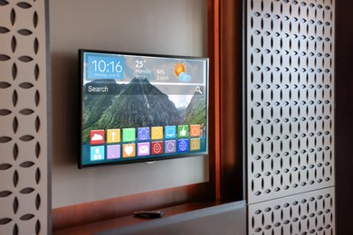 Image of TV set showing menu with icons and information on display in room