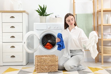 Photo of Woman with laundry near washing machine indoors