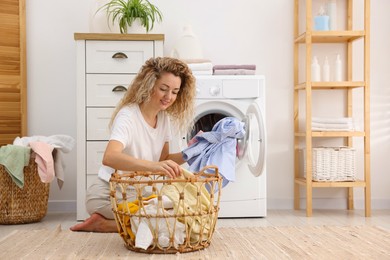 Photo of Woman with laundry near washing machine indoors