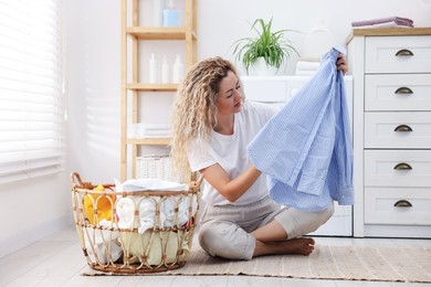 Photo of Woman with laundry near washing machine indoors