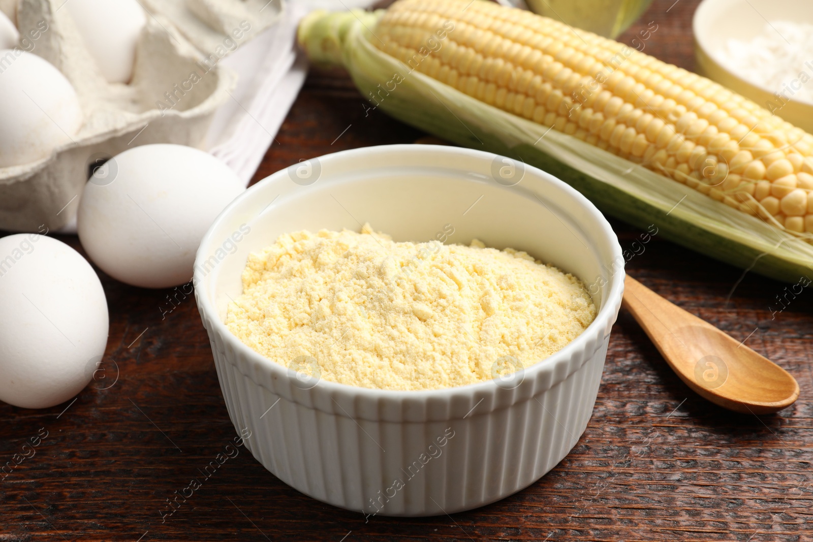 Photo of Different ingredients for corn bread. Corn flour, cob and eggs on wooden table, closeup