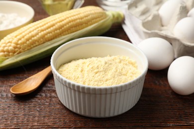 Photo of Different ingredients for corn bread. Corn flour, cob and eggs on wooden table, closeup