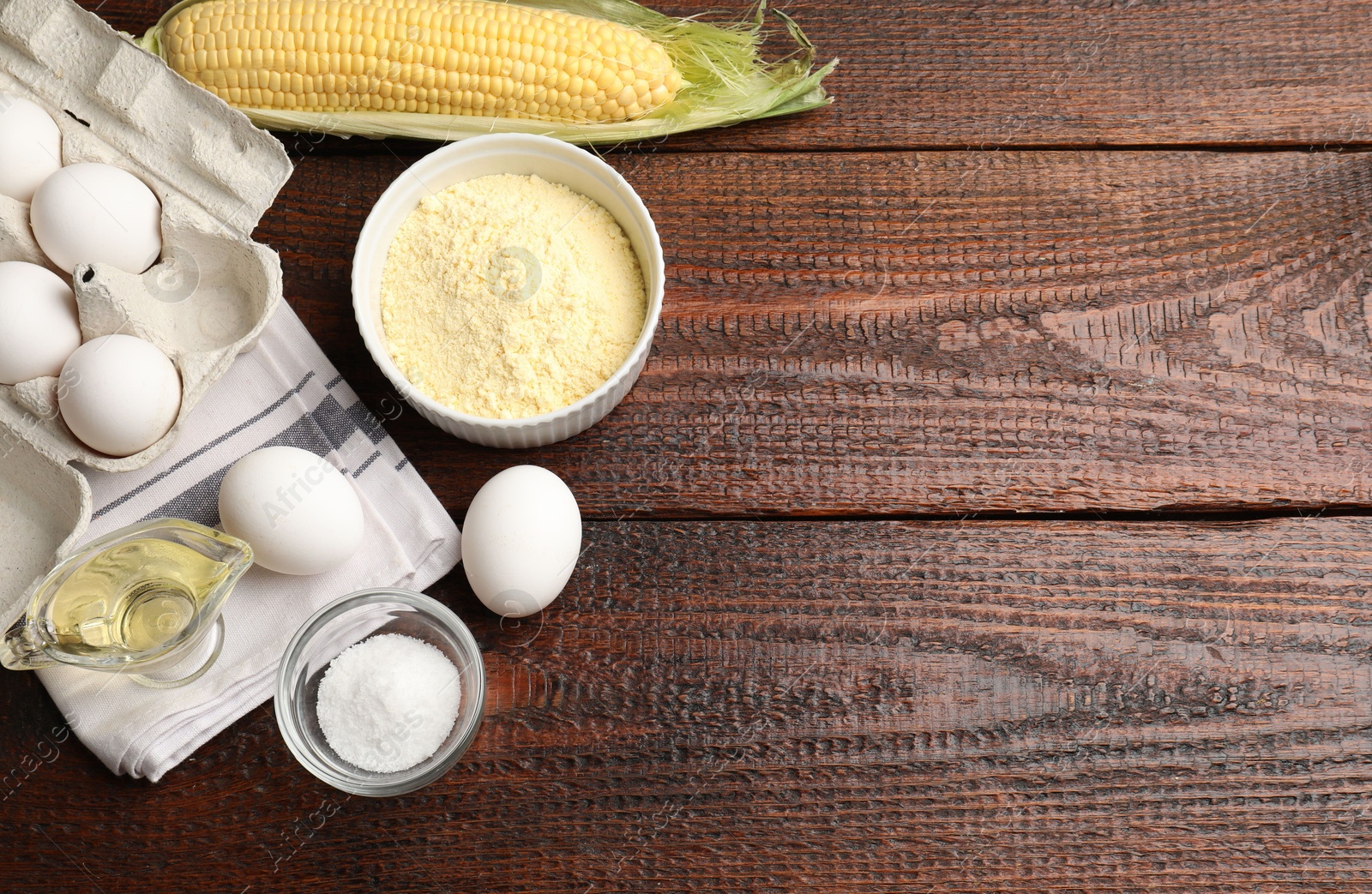 Photo of Different ingredients for corn bread on wooden table, flat lay. Space for text
