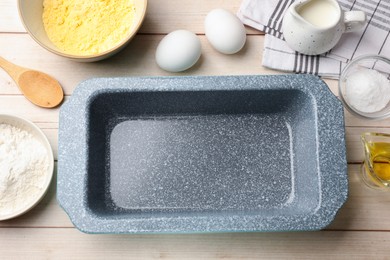 Photo of Baking dish and different ingredients for corn bread on light wooden table, flat lay. Space for text