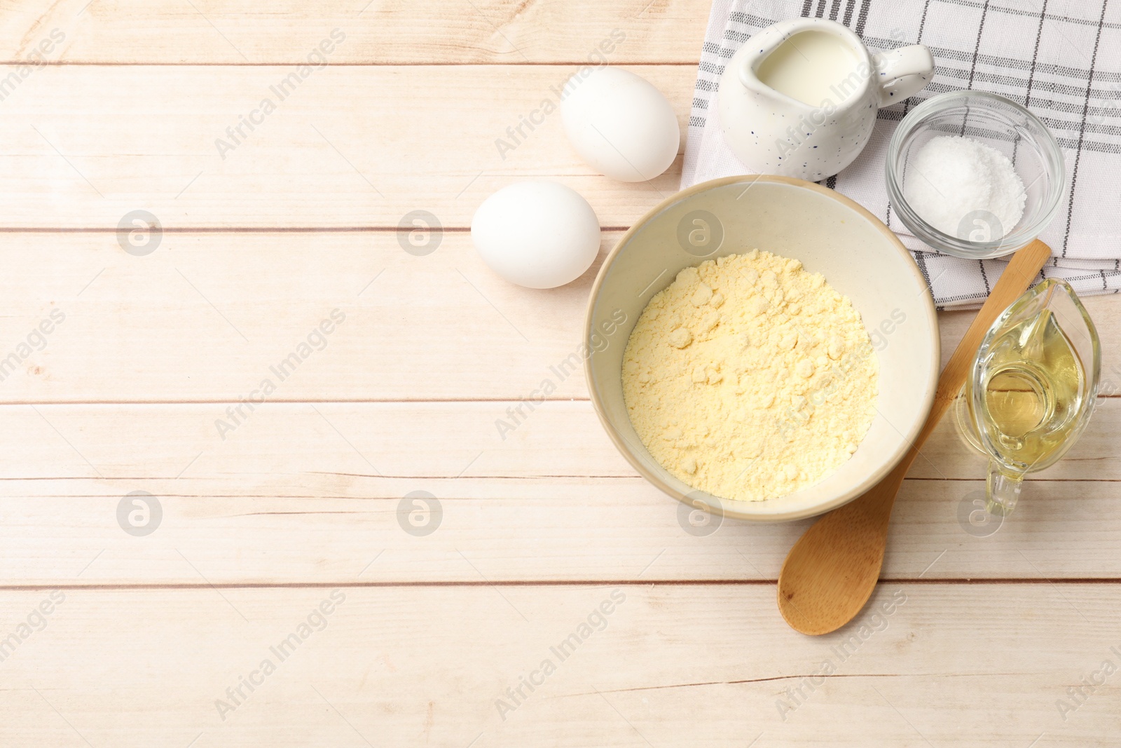 Photo of Different ingredients for corn bread on light wooden table, flat lay. Space for text