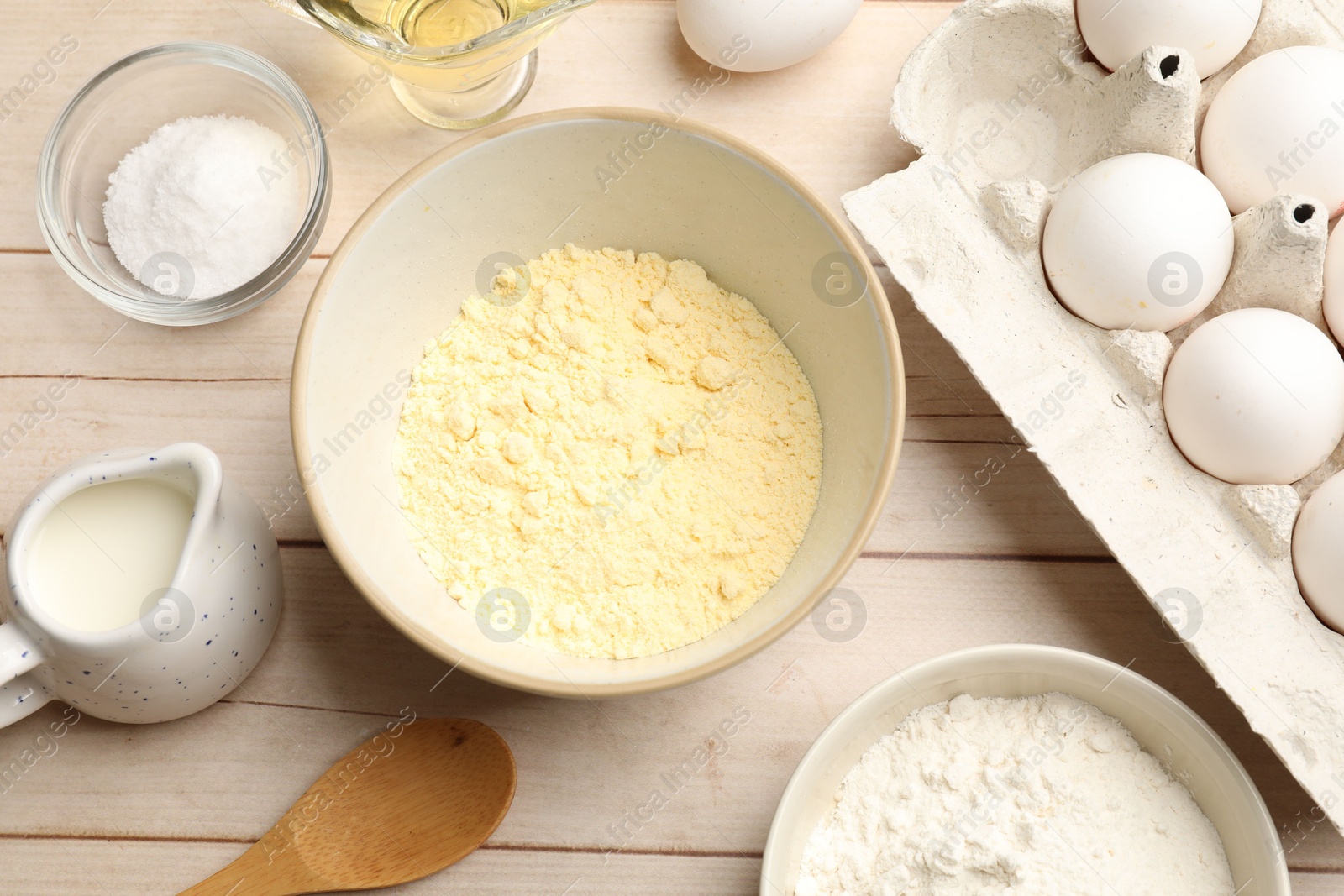 Photo of Different ingredients for corn bread on light wooden table, flat lay