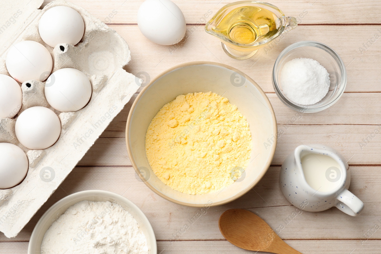 Photo of Different ingredients for corn bread on light wooden table, flat lay