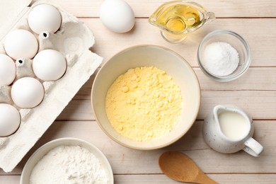 Photo of Different ingredients for corn bread on light wooden table, flat lay