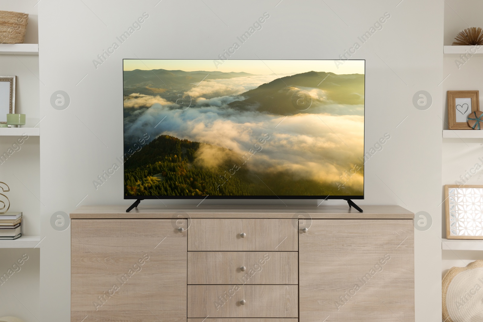 Image of TV set on console in room. Mountain landscape on screen