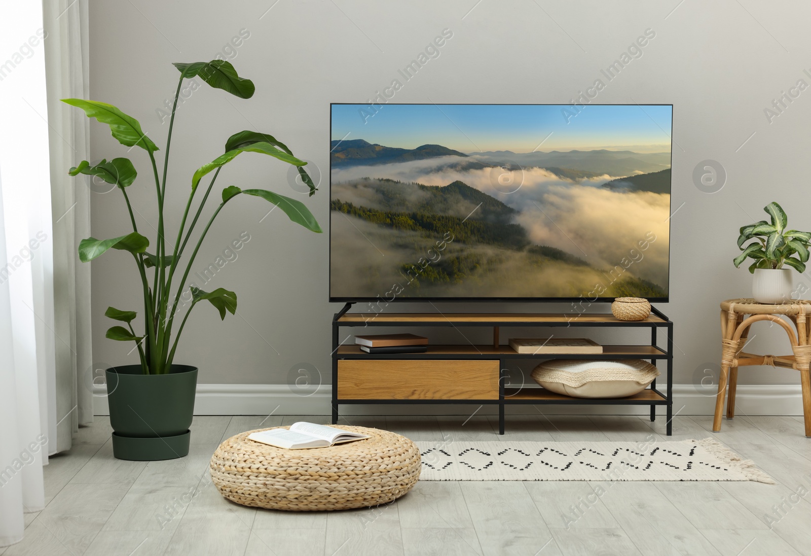 Image of TV set on console in room. Mountain landscape on screen