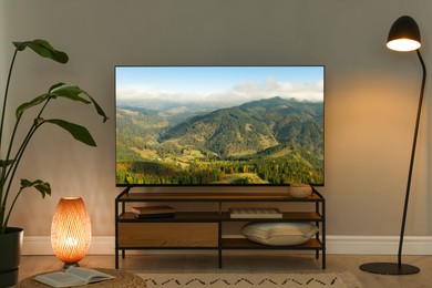 Image of TV set on console in room. Mountain landscape on screen