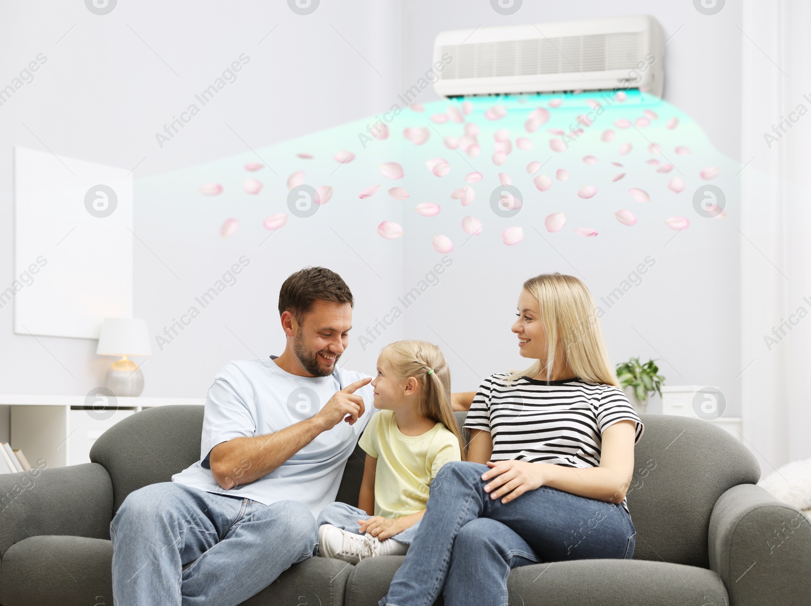 Image of Happy family on sofa in room with air conditioner