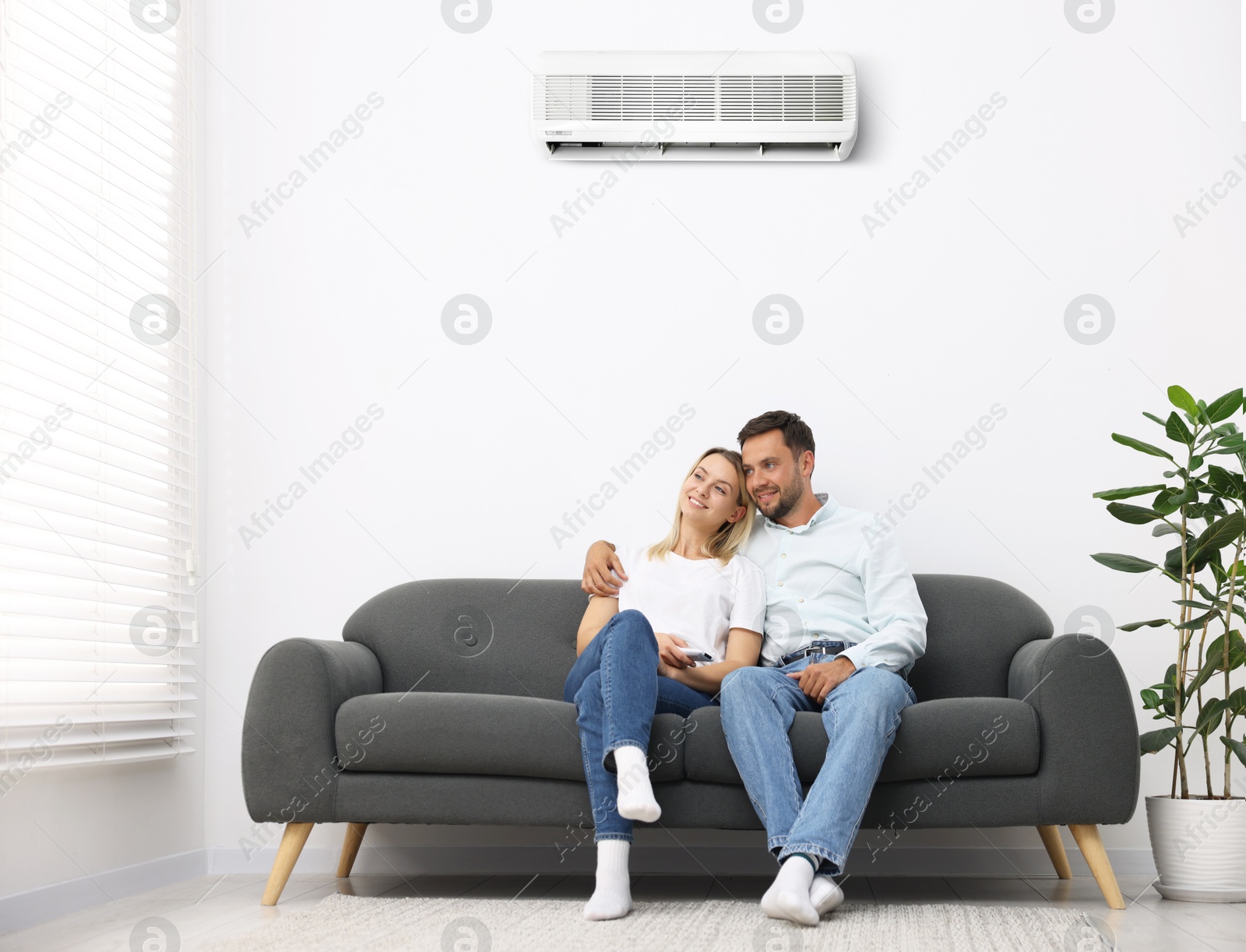 Image of Couple on sofa in room with air conditioner
