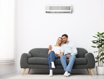 Image of Couple on sofa in room with air conditioner