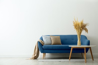 Image of Living room with blue sofa and side table. Interior design