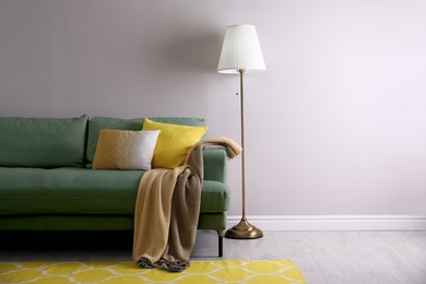 Image of Living room with green sofa and floor lamp. Interior design