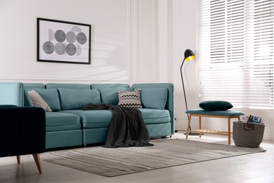Image of Living room with light blue sofa and other furniture. Interior design