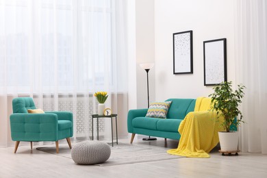 Image of Living room with turquoise sofa and other furniture. Interior design
