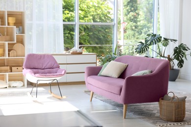 Image of Living room with pink sofa and rocking chair. Interior design