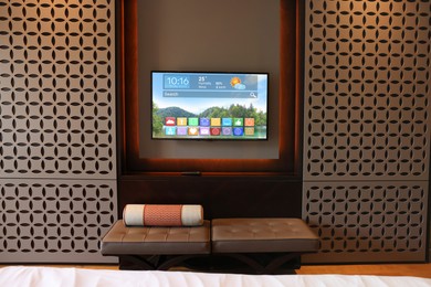 Image of TV set in room. Menu with icons and information on display