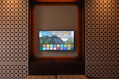 Image of TV set showing menu with icons and information on display in room