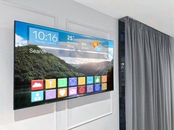 Image of TV set on wall in room. Menu with icons and information on display