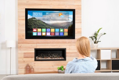 Image of Woman watching TV at home, back view. Menu with icons and information on display
