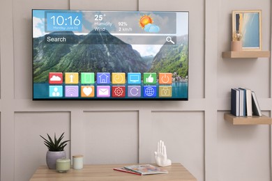 Image of TV set on wall in room. Menu with icons and information on display