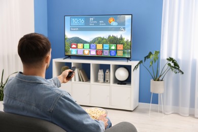 Image of Man watching TV at home. Menu with icons and information on display