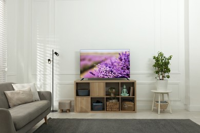 Image of TV set on console in room. Lavender field on screen