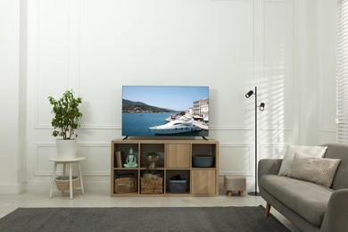 Image of TV set on console in room. Landscape on screen