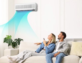 Image of Couple resting on sofa at home. Woman using remote to control air conditioner
